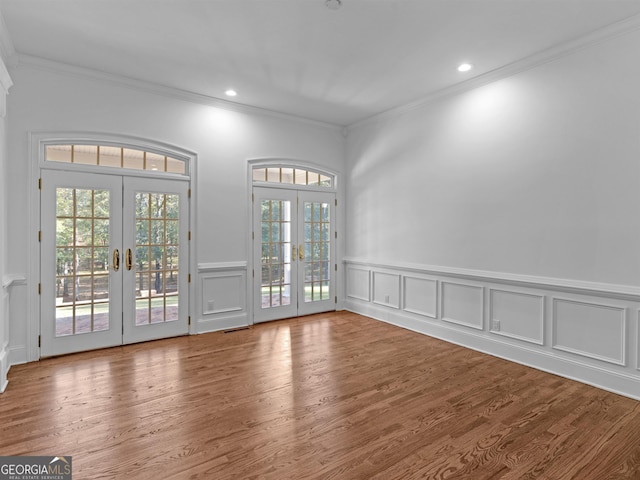 interior space with french doors, recessed lighting, wood finished floors, and crown molding