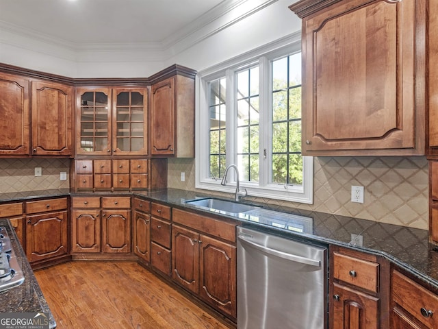 kitchen with a sink, light wood-type flooring, dishwasher, tasteful backsplash, and crown molding