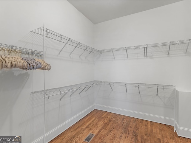 walk in closet featuring visible vents and wood finished floors