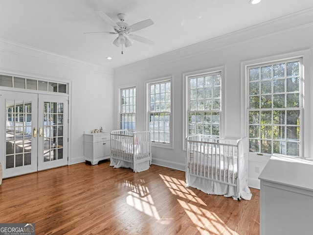 unfurnished bedroom featuring recessed lighting, wood finished floors, baseboards, ornamental molding, and french doors