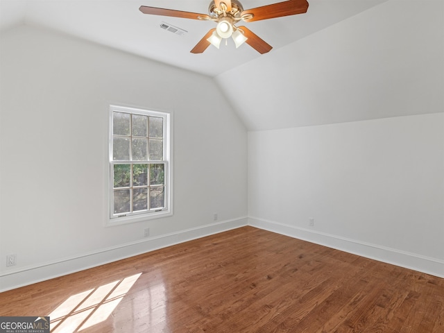 bonus room featuring lofted ceiling, visible vents, baseboards, and wood finished floors