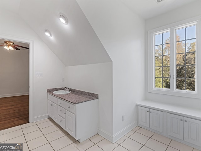 bathroom with vaulted ceiling, tile patterned flooring, and baseboards