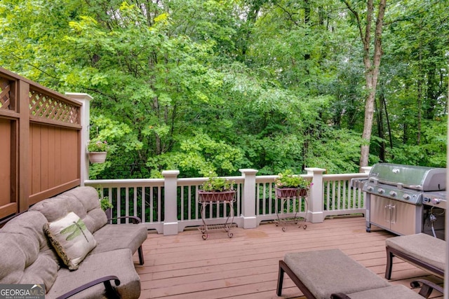 wooden terrace featuring a wooded view and area for grilling