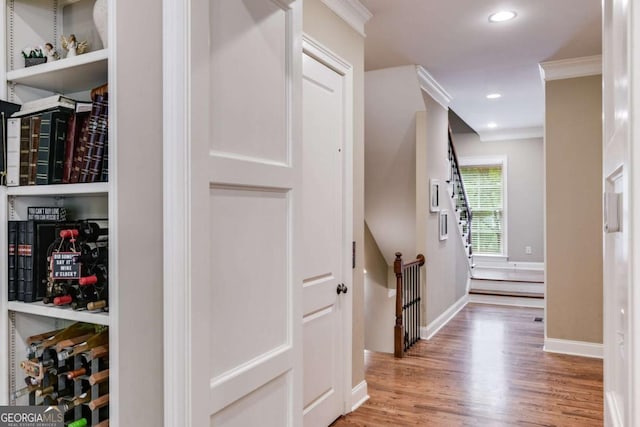 hall featuring ornamental molding, recessed lighting, baseboards, and wood finished floors