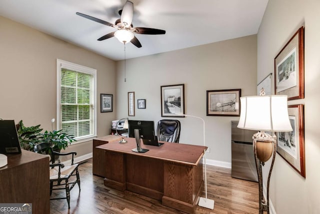 office area with wood finished floors, a ceiling fan, and baseboards