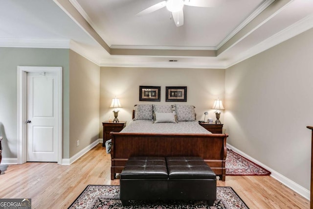 bedroom featuring light wood-type flooring, crown molding, and baseboards