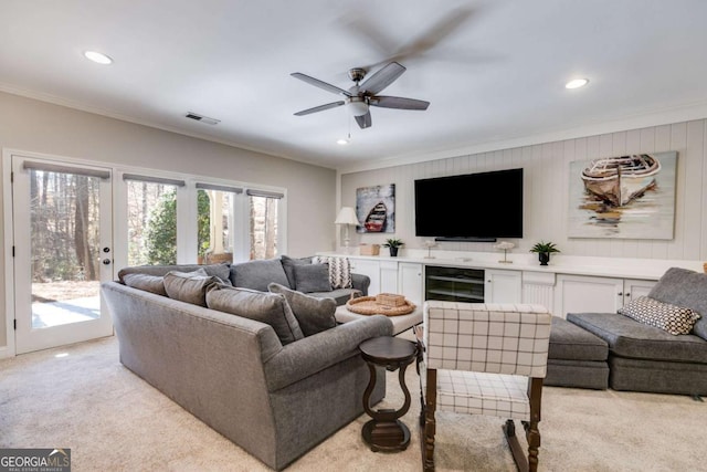 living room featuring beverage cooler, visible vents, crown molding, and light carpet