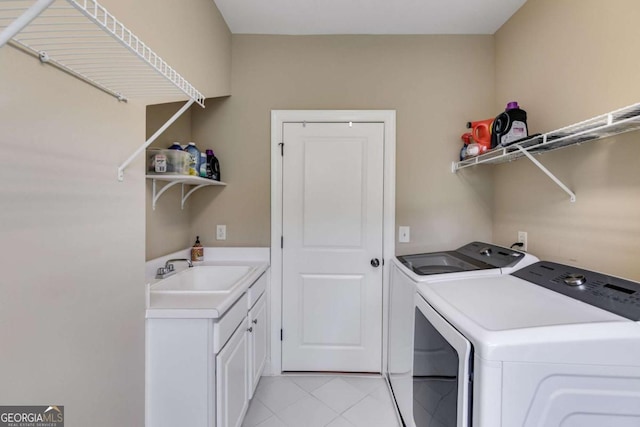 clothes washing area with cabinet space, light tile patterned floors, a sink, and independent washer and dryer