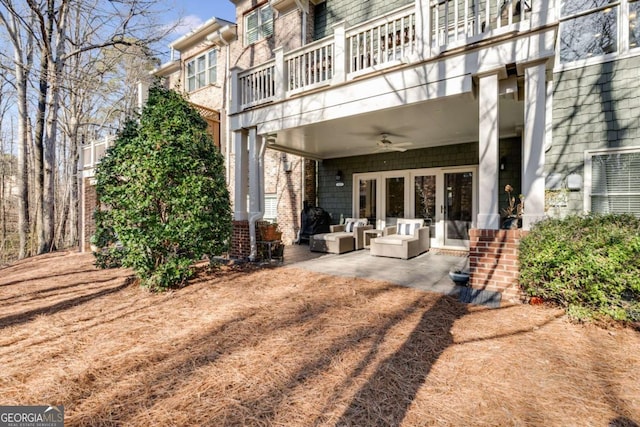 back of property with french doors, a patio, a ceiling fan, a balcony, and an outdoor living space