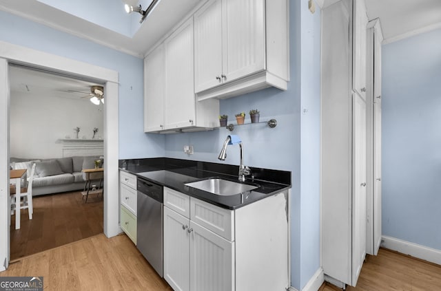 kitchen featuring a sink, dark countertops, light wood-style flooring, and dishwasher