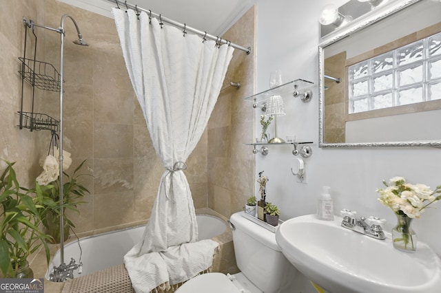 bathroom with a sink, tiled shower / bath combo, and toilet