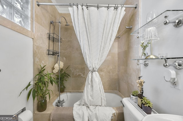 full bathroom featuring tiled shower / bath combo and toilet