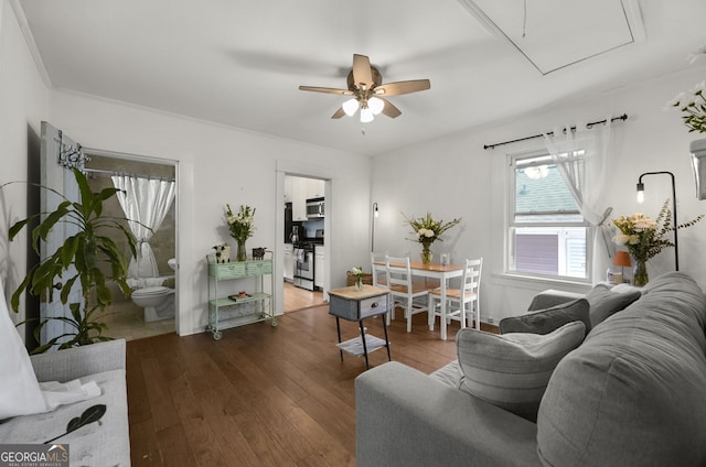 living room featuring hardwood / wood-style flooring, attic access, and a ceiling fan