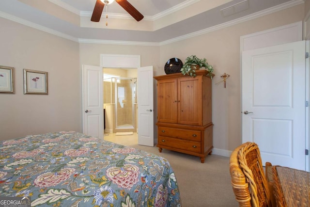 bedroom with ornamental molding, a raised ceiling, connected bathroom, and light colored carpet