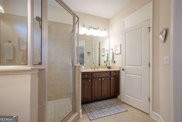 full bathroom with a stall shower, vanity, baseboards, and tile patterned floors