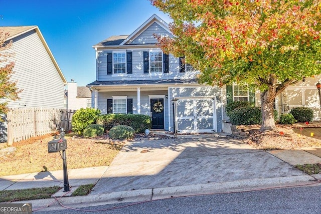 view of front of home with a garage, fence, and concrete driveway