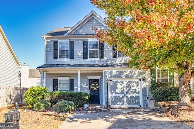 view of front of property featuring concrete driveway and fence