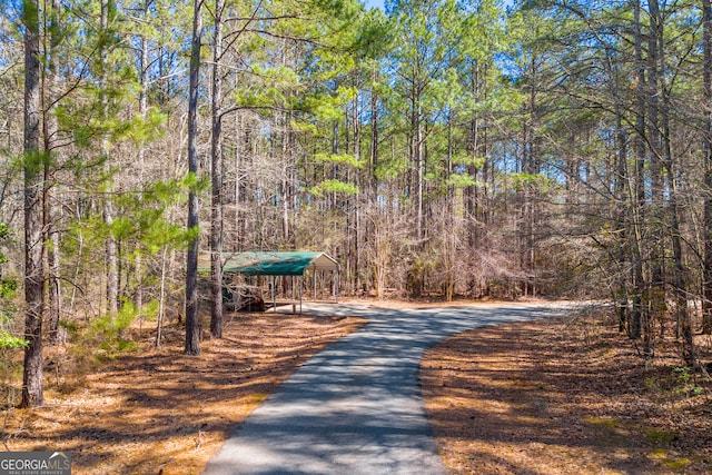 view of road featuring driveway and a forest view