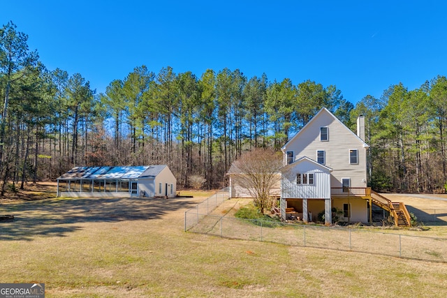 view of side of property featuring a chimney, a lawn, fence private yard, an outdoor structure, and stairs