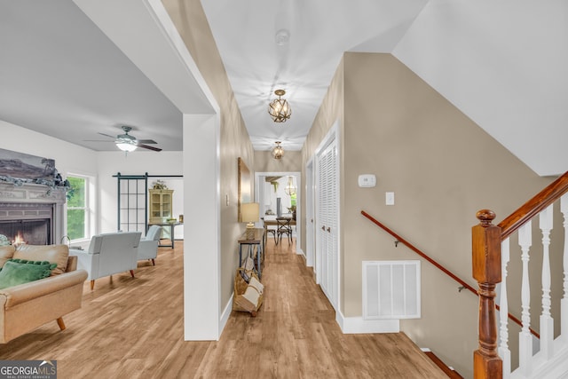 599 Double Branch Rd, Danielsville, GA 30633 - foyer entrance with light wood-style floors, stairway, a lit fireplace, baseboards, and a ceiling fan