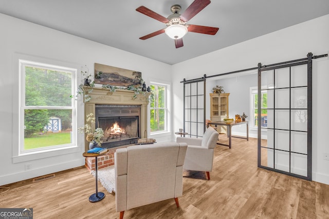 599 Double Branch Rd, Danielsville, GA 30633 - living room with a barn door, wood finished floors, ceiling fan, and baseboards