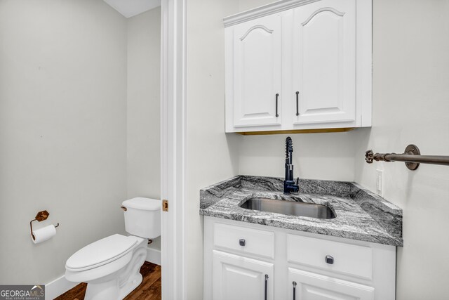 599 Double Branch Rd, Danielsville, GA 30633 - half bathroom with toilet, wood finished floors, baseboards, and vanity