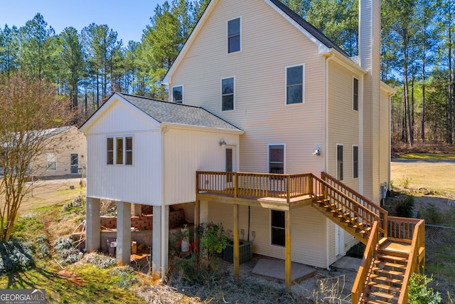 rear view of property with a patio, a chimney, a shingled roof, stairway, and a wooden deck