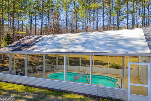 outdoor pool with a sunroom and a patio