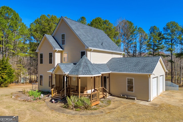 back of property with a garage, roof with shingles, and covered porch