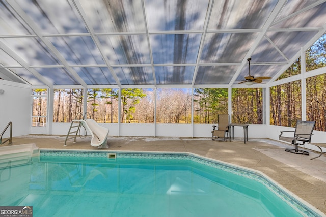 indoor pool with a water slide, a patio area, and a lanai