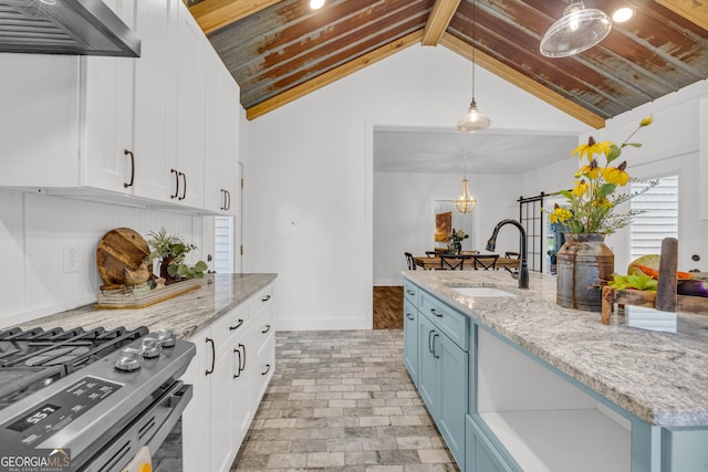 599 Double Branch Rd, Danielsville, GA 30633 - kitchen featuring a sink, stainless steel range with gas cooktop, blue cabinetry, white cabinetry, and vaulted ceiling