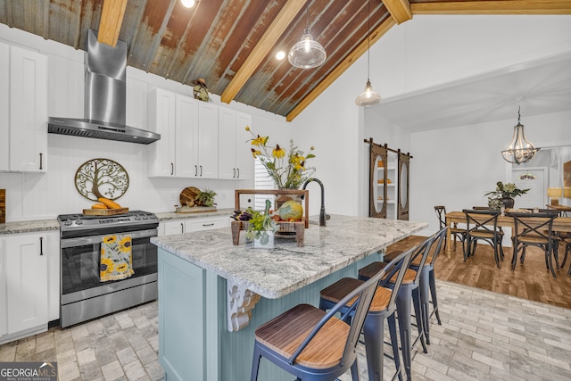 599 Double Branch Rd, Danielsville, GA 30633 - kitchen featuring gas range, wall chimney exhaust hood, a barn door, light stone countertops, and a kitchen island with sink