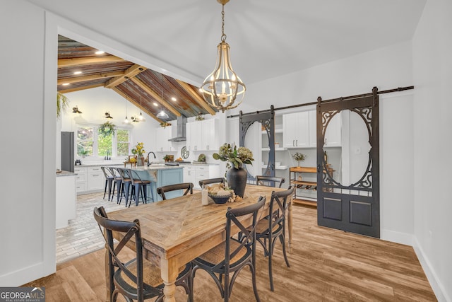 599 Double Branch Rd, Danielsville, GA 30633 - dining room with a barn door, light wood-type flooring, a chandelier, and baseboards