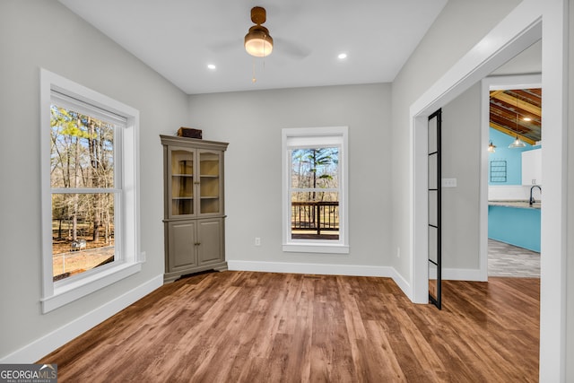 unfurnished dining area featuring recessed lighting, wood finished floors, a ceiling fan, and baseboards