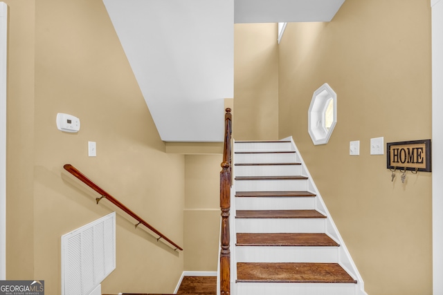 stairway featuring visible vents and baseboards