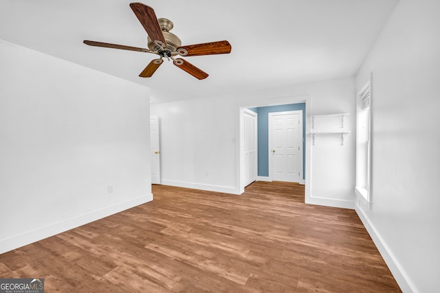 unfurnished bedroom with ceiling fan, baseboards, and wood finished floors