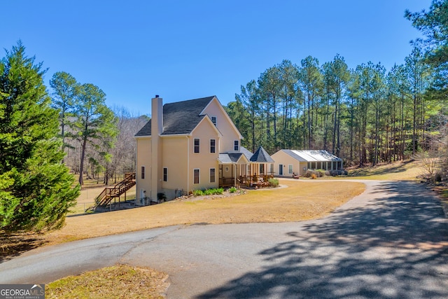 599 Double Branch Rd, Danielsville, GA 30633 - view of side of home featuring a chimney, stairway, asphalt driveway, and roof with shingles