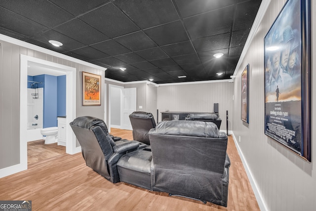 home theater room featuring crown molding, baseboards, and wood finished floors