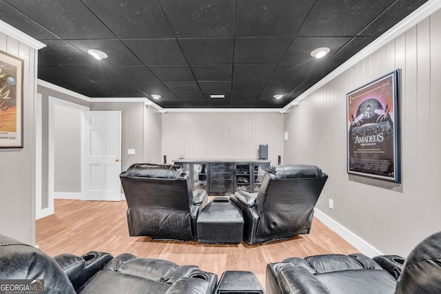 home theater featuring baseboards, wood finished floors, and crown molding