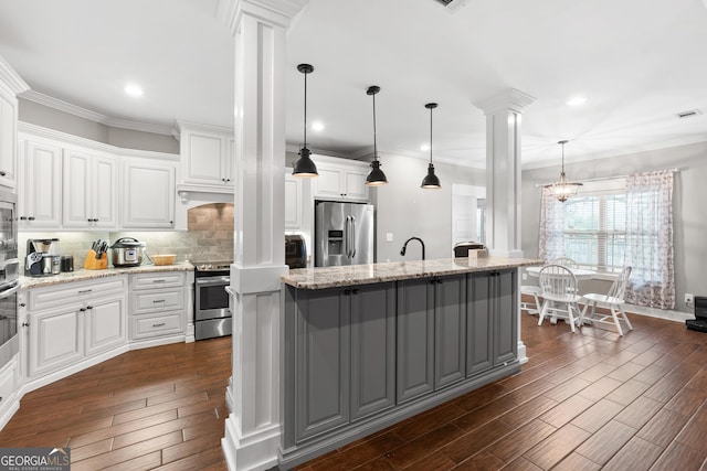 kitchen featuring ornate columns, white cabinetry, dark wood-style floors, and appliances with stainless steel finishes