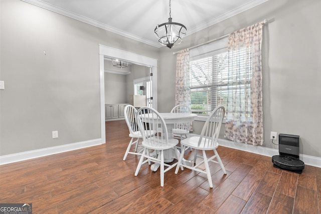 dining area featuring ornamental molding, a notable chandelier, baseboards, and wood finished floors