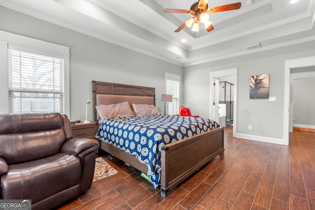 bedroom featuring dark wood-style floors, a raised ceiling, visible vents, ornamental molding, and baseboards