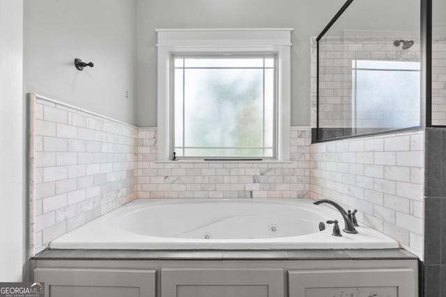 bathroom with a tile shower and a whirlpool tub