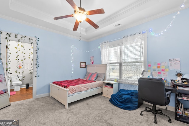 bedroom with baseboards, visible vents, a raised ceiling, crown molding, and carpet flooring