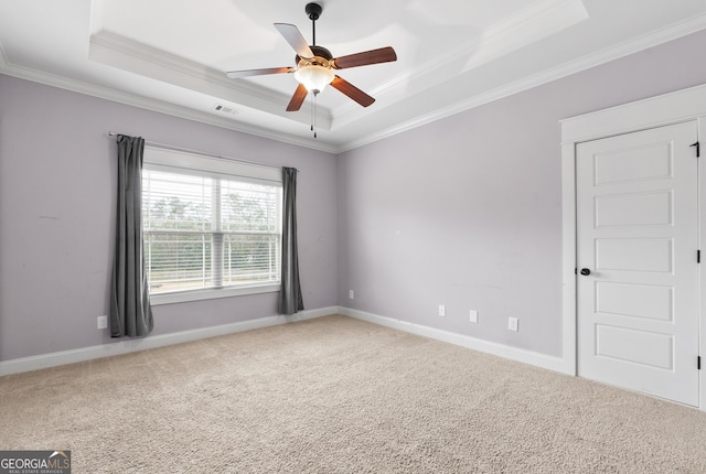 unfurnished room with carpet floors, visible vents, and a tray ceiling