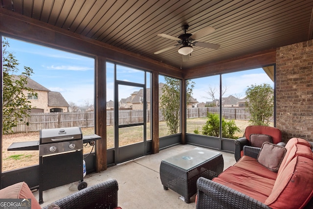 sunroom with a ceiling fan and a residential view