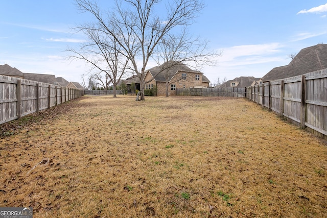 view of yard featuring a fenced backyard and a residential view