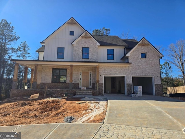 view of front of home featuring concrete driveway, a porch, board and batten siding, and an attached garage