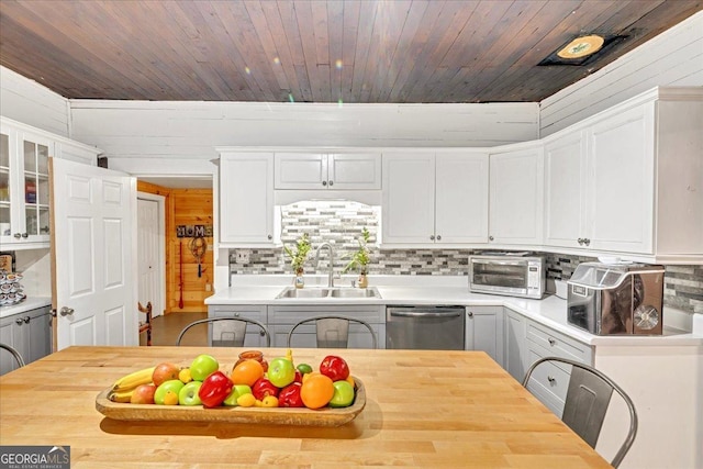 kitchen featuring a sink, butcher block countertops, decorative backsplash, and dishwasher