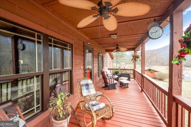 wooden terrace featuring ceiling fan and a mountain view